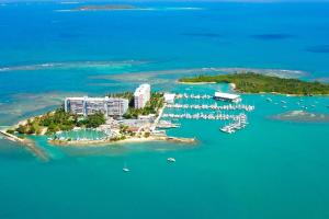 an island with a resort and boats in the water at Island bliss apartment in Fajardo