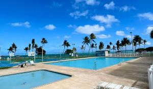 a swimming pool with the ocean in the background at Island bliss apartment in Fajardo