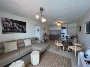 a living room with a couch and a kitchen at Island bliss apartment in Fajardo
