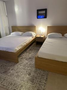 two beds in a bedroom with a tv on the wall at Island bliss apartment in Fajardo +15 photos
