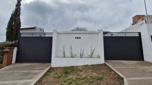 a white garage with two gates with plants at Cabaña Matorras 480 in Tandil +34 photos