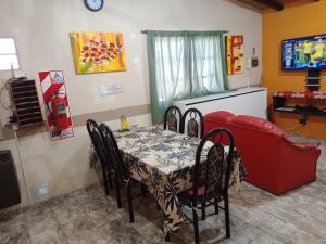 una sala da pranzo con tavolo e divano rosso di Malargue Style a 100 MTS del Centro a Malargüe