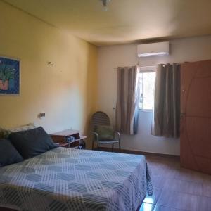 a bedroom with a bed and a window at Carolina com Ká in Carolina