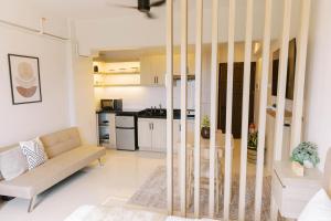 a living room with a couch and a kitchen at Bright Modern Stay with Balcony & Ocean Breeze in Dao