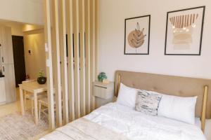 a bedroom with a bed and a table with a desk at Bright Modern Stay with Balcony & Ocean Breeze in Dao +32 photos