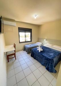 a room with two beds and a cross on the floor at Pousada Pedra Bonita in Cristal
