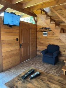 een kamer met een tv en twee afstandsbedieningen op een tafel bij cabañas walls 3 in Pucón