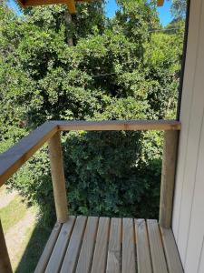 een veranda met een houten terras met bomen op de achtergrond bij cabañas walls 3 in Pucón