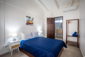 a bedroom with a blue bed and a bathroom at Ozeano Hotel & Surf Bar in Jacó +54 photos