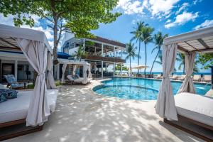 a resort with a swimming pool with two beds at Ozeano Hotel & Surf Bar in Jacó