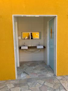 un bagno con due lavandini in una parete gialla di Casa de Férias para sua Família e seu Pet! a Itatiaia Altre 23 foto