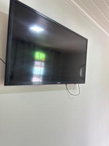 a flat screen tv hanging on a wall at Suite em Hospedagem 100m da BR! in São José