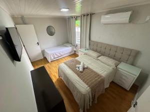 a bedroom with a bed and a table in it at Suite em Hospedagem 100m da BR! in São José