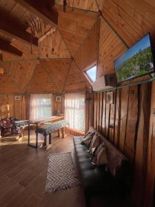 a living room with a couch and a flat screen tv at Domo Kuram in Ancud