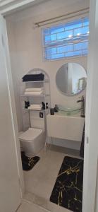 a bathroom with a toilet and a sink and a mirror at Martha's House Kia in Soufrière