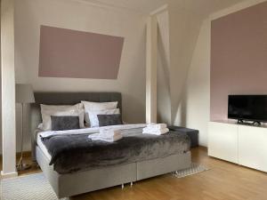 a bedroom with a large bed and a television at Villa Schlossblick I - Zeit zum Entspannen in exklusiver Ferienwohnung mit Panoramablick, Parkplatz, WLAN, Smart-TV in Wernigerode +36 photos