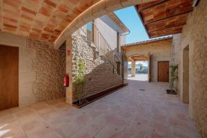 an empty hallway with a brick wall and an archway at Hotel Mas Vidal Vilafreser in Vilademuls