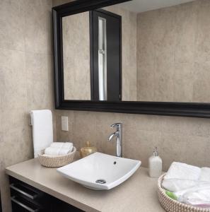 un bagno con lavandino e specchio di Blue Tulip - Strovolos a Kato Lakatamia Altre 7 foto