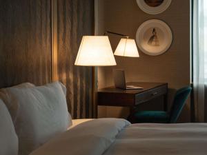 ein Hotelzimmer mit einem Bett und einem Schreibtisch mit einer Lampe in der Unterkunft Manto Hotel Lima - MGallery Collection in Lima + 185 Fotos