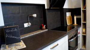 a kitchen with a black counter top with a chalkboard at Apartment 24 modern & gemütlich in Dessau