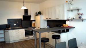 a kitchen with white cabinets and a black counter top at Apartment 24 modern & gemütlich in Dessau +49 photos