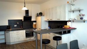 a kitchen with white cabinets and black counter tops at Apartment 24 modern & gemütlich in Dessau