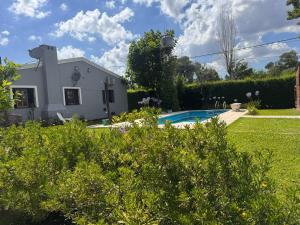 a house with a swimming pool in a yard at Quinta La Berna in Etchegoyen