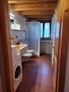a bathroom with a toilet and a washing machine at Casa Sole in Ceniga +11 photos