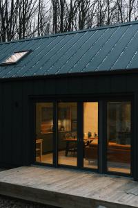 ein schwarzes Haus mit Solardach auf einer Terrasse in der Unterkunft Forester Cabin in Telega