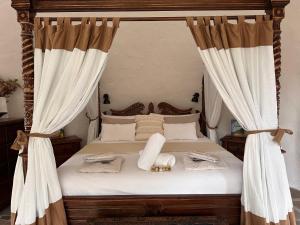 a bedroom with a canopy bed with white curtains at Sunshine Coast Hinterland Igloo Retreat Romantic & Private in Flaxton