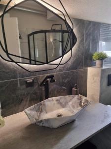 a bathroom with a marble sink and a mirror at Apartman Lipik in Lipik