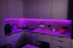 a kitchen with purple lights on the counters at Apartament Corner Cappuccino z wanną z hydromasażem w centrum Tomaszowa! Parliamo anche Italiano! in Tomaszów Mazowiecki