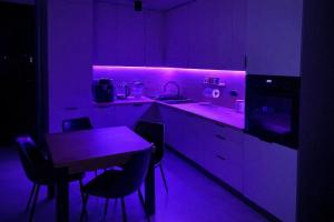 a purple kitchen with a table and a purple lighting at Apartament Corner Cappuccino z wanną z hydromasażem w centrum Tomaszowa! Parliamo anche Italiano! in Tomaszów Mazowiecki