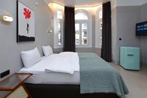 a large white bed in a room with windows at Paradox in Thessaloniki