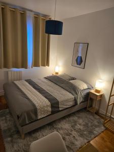 a bedroom with a bed and two lamps and a window at Chambre idéalement située in Villeurbanne