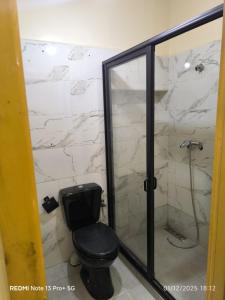 a bathroom with a toilet and a glass shower at Appartement in Mohammedia +5 photos