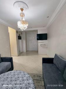 a living room with a couch and a chandelier at Appartement in Mohammedia