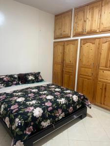 a bedroom with a bed and wooden cabinets at Appartement in Mohammedia