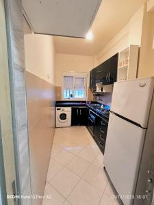 a kitchen with a white refrigerator and a dishwasher at Appartement in Mohammedia