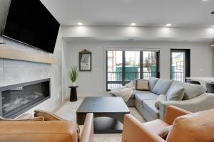 een woonkamer met een bank en een open haard bij 3 Bedroom with Heated Outdoor Pool and Hottub! in Canmore