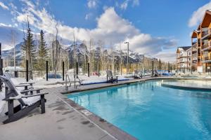 een zwembad met besneeuwde bergen op de achtergrond bij 3 Bedroom with Heated Outdoor Pool and Hottub! in Canmore