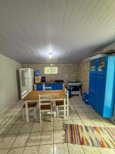 a kitchen with a wooden table and blue cabinets at Casa aconchegante e tranquila in Chapada dos Guimarães +8 photos