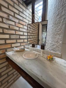 a bathroom with a sink and a brick wall at Pousada Ventoria in Canguaretama