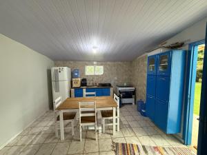 a kitchen with a wooden table and blue cabinets at Casa aconchegante e tranquila in Chapada dos Guimarães