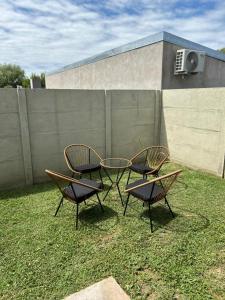 two chairs and a table in a yard with a fence at CasaMar in General Villegas