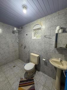 a bathroom with a toilet and a sink at Casa aconchegante e tranquila in Chapada dos Guimarães