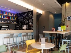 ein Restaurant mit Tischen und Stühlen und eine Bar in der Unterkunft ibis Chia in Chía
