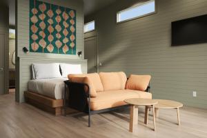 a bedroom with a bed and a couch and a tv at Outbound Yosemite in Oakhurst