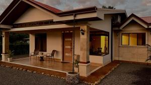 a small house with a porch with a table at Arenal Stone House in Ángeles