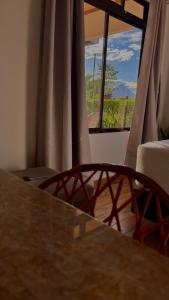 a table and chairs in a room with a window at Arenal Stone House in Ángeles